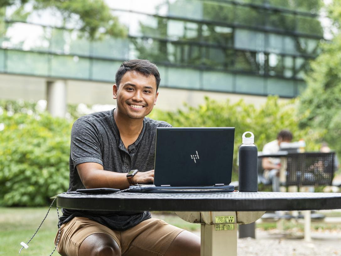 Student studying his class notes on his laptop.